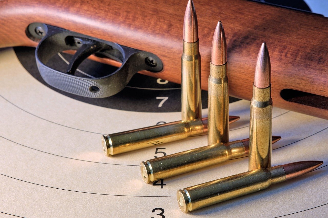 a gun and ammo on a white paper target